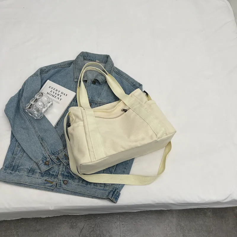 Large solid colour polyester canvas shoulder tote bag for women with outer pocket.