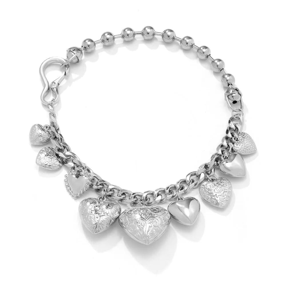 Carved heart-shaped pendant necklace on a metal chain, shown in gold and white K colour options.