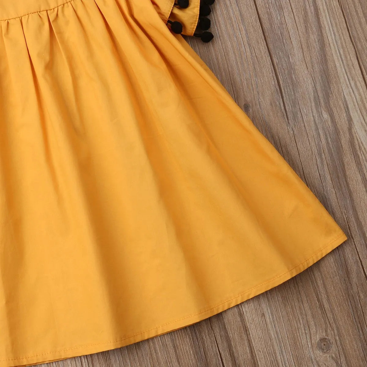 Orange sleeveless dress for toddler girl with shirring detail on front and elasticated back.