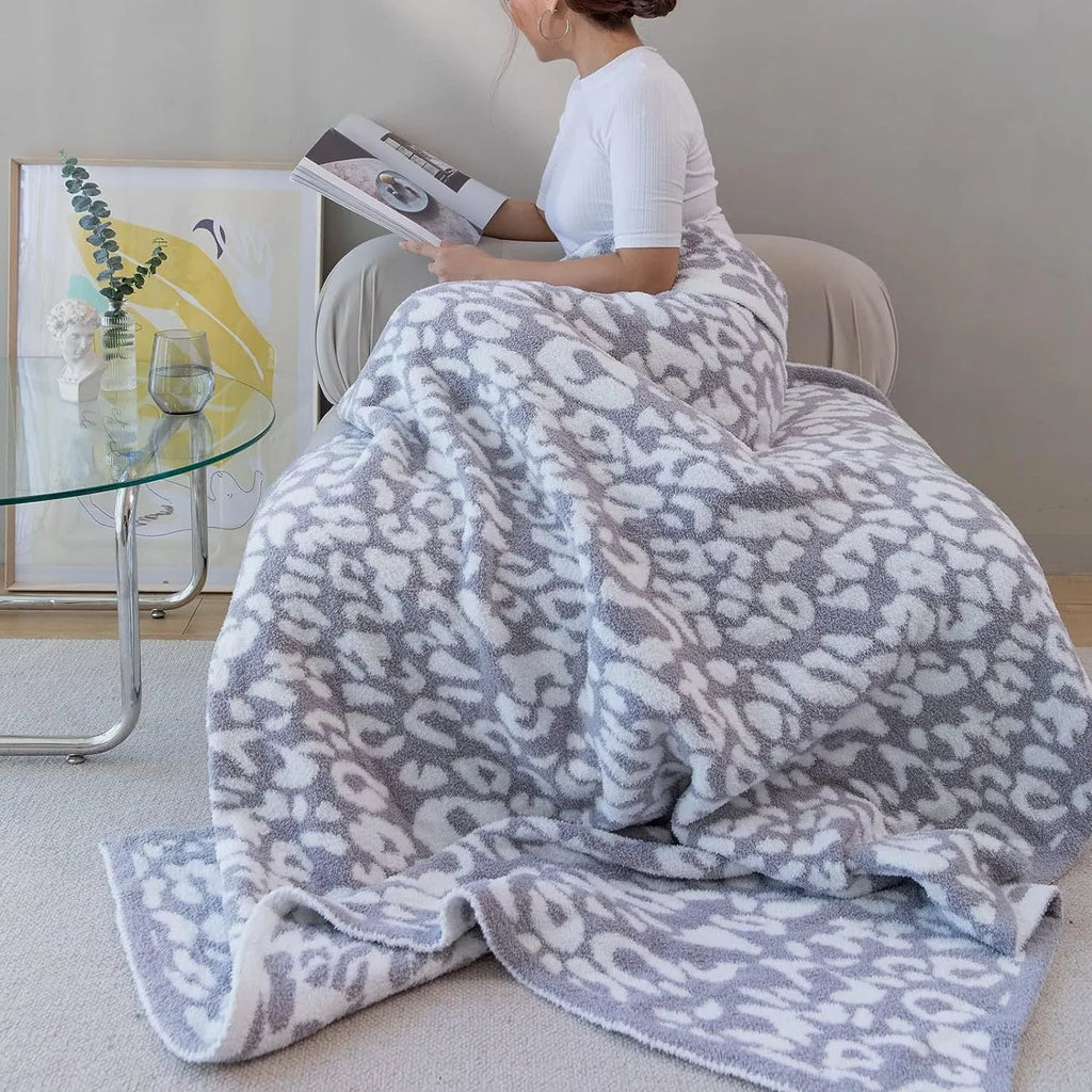 Half velvet leopard print knitted blanket in gray on a sofa, size 130x150cm