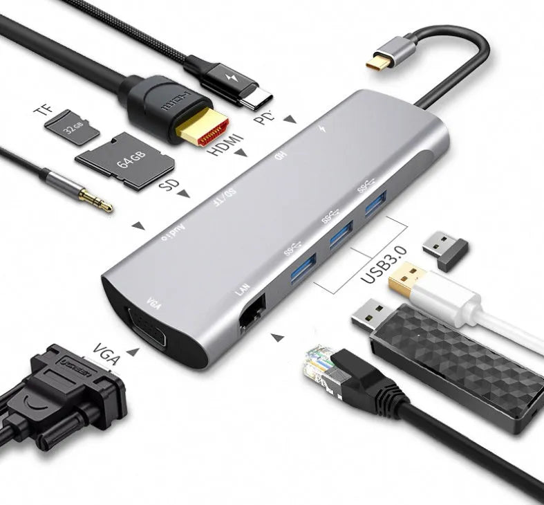 Grey aluminium USB-C docking station with HDMI, VGA, USB 3.0, and PD charge ports on a wooden desk.
