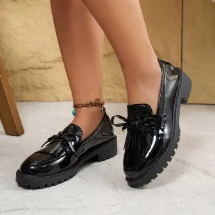 Brown women's flat loafers with a decorative bow on the front.