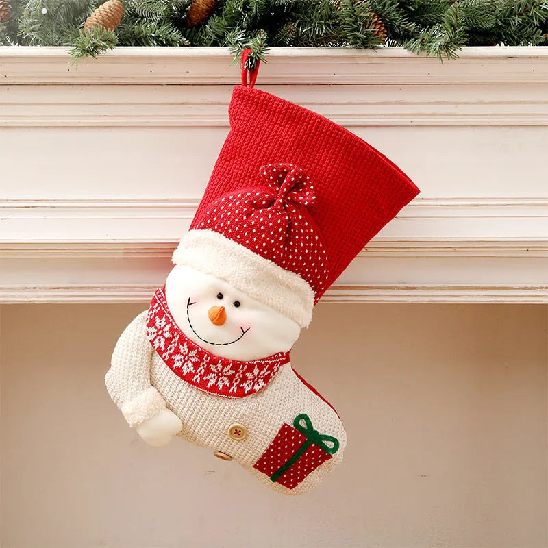 Large red and white knitted Christmas stocking with Santa Claus design hanging on a fireplace