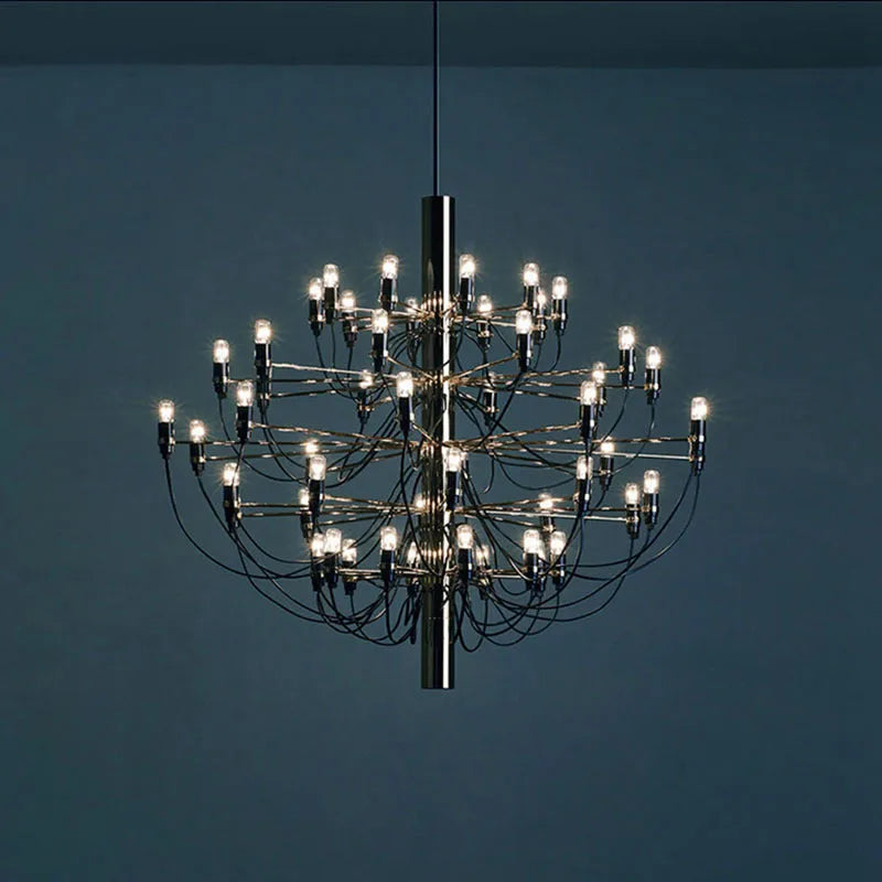 Modern three fork floor lamp in natural wood with acrylic shade on a living room floor.