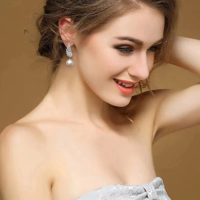 Silver angel wing earrings with diamond-cut treatment and gemstone inlay on platinum background