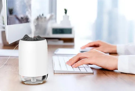 Mini cylindrical USB humidifier with night light in turquoise green, showing water tank and mist outlet