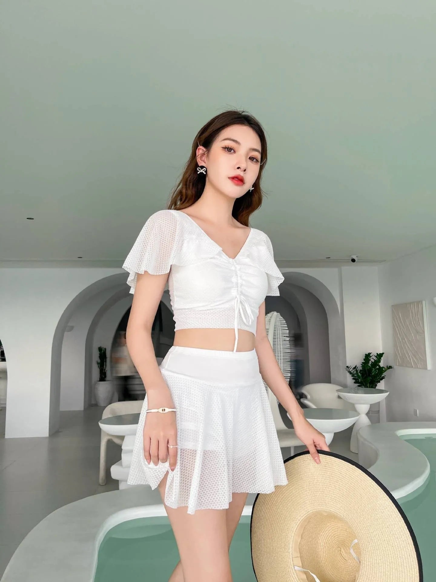 Women's solid colour two-piece swimsuit with a skirt, shown in white, black, and pink.