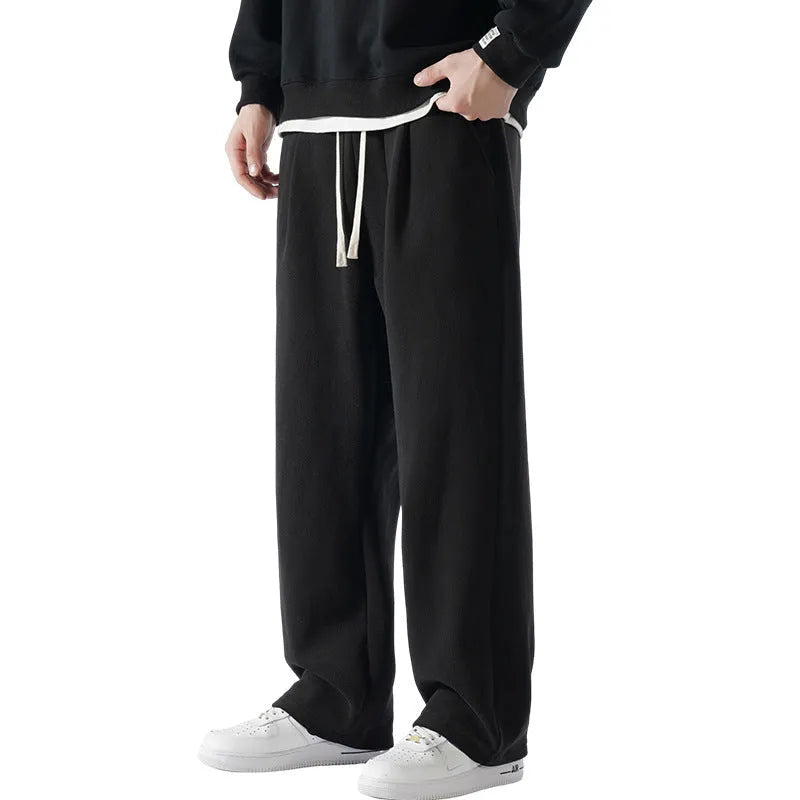 Men's apricot fleece-lined casual sports trousers with a loose fit and drawstring waist, laid flat.
