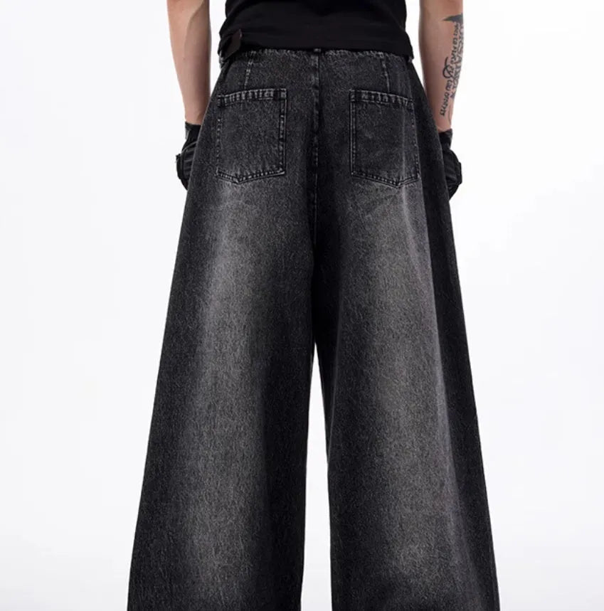 Black and grey washed wide leg cotton denim trousers and matching waistcoat set laid flat.