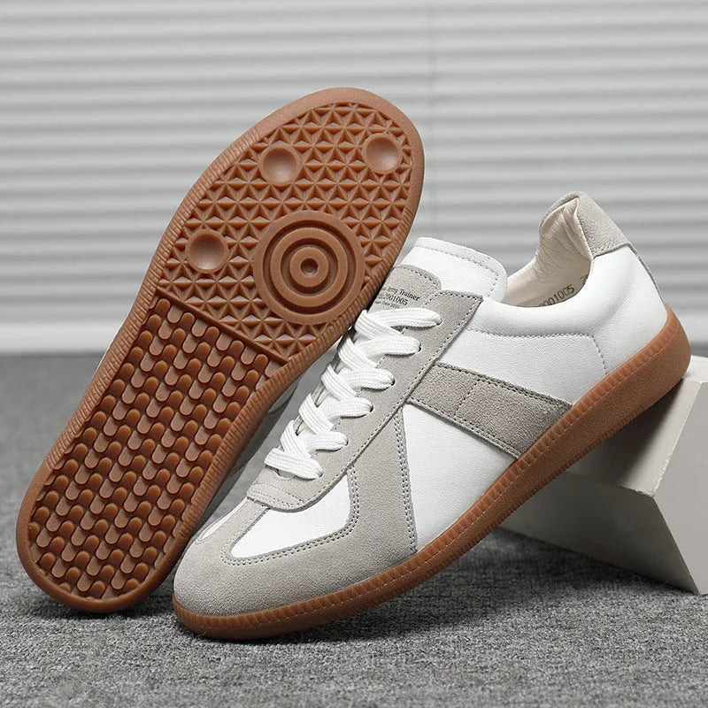 White Japanese-style retro low-top sneakers with round toe and flat rubber sole on a plain background.