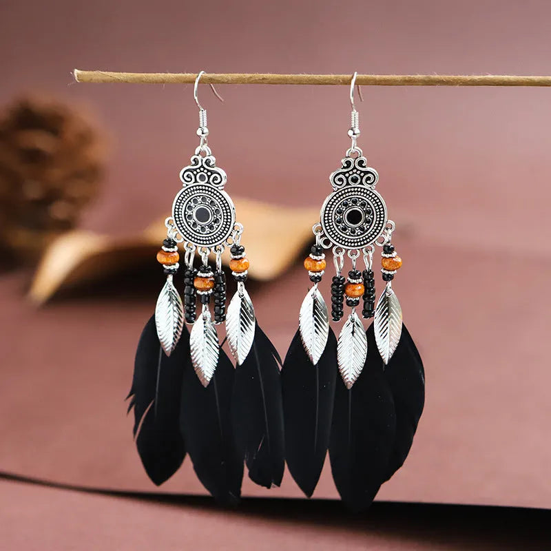 Round drop feather earrings in alloy with electroplated finish showing leaf shape and pattern details