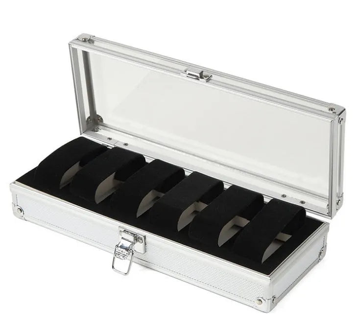 Brushed aluminium watch box holding six watches with a front jewellery storage bin.