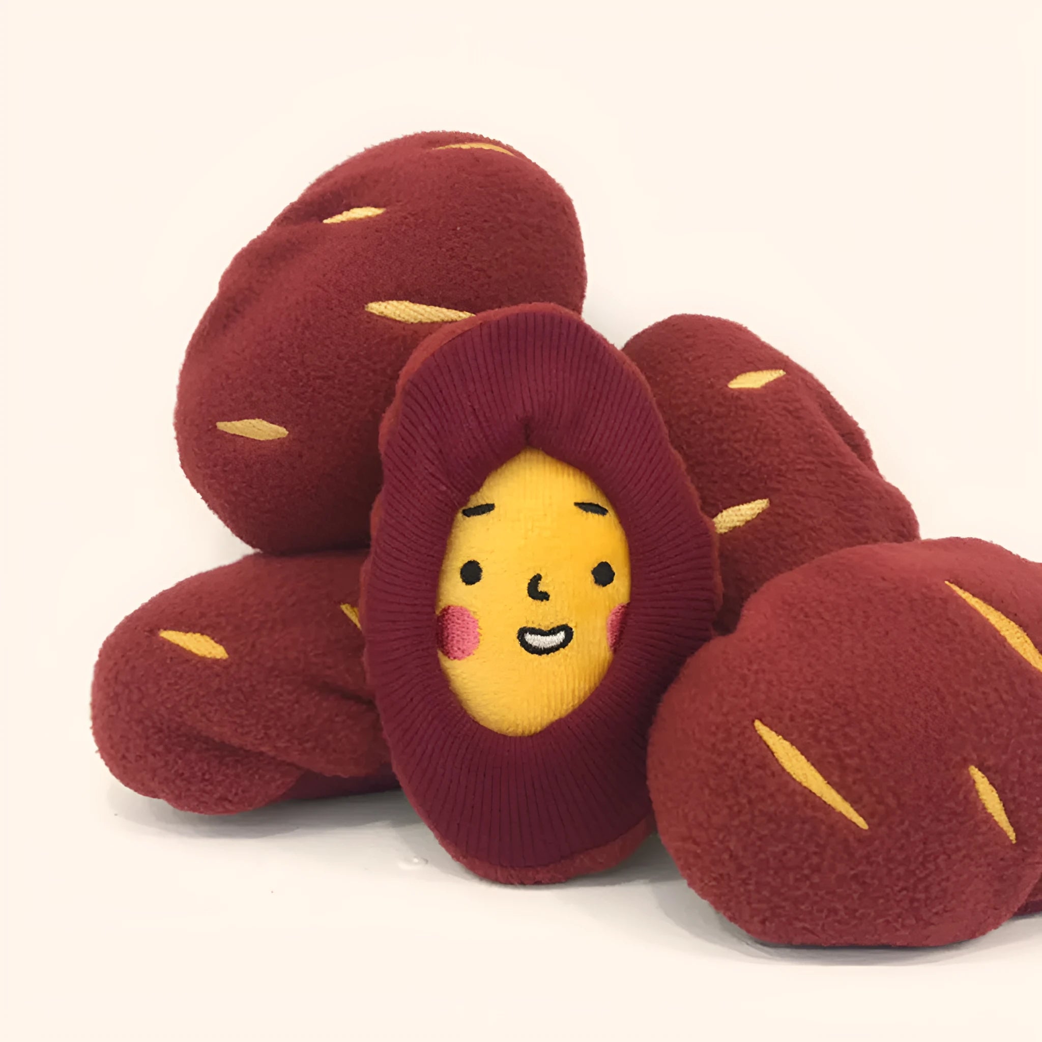 Red sweet potato-shaped dog toy with hidden food pockets and wrap-up design for treat puzzles.