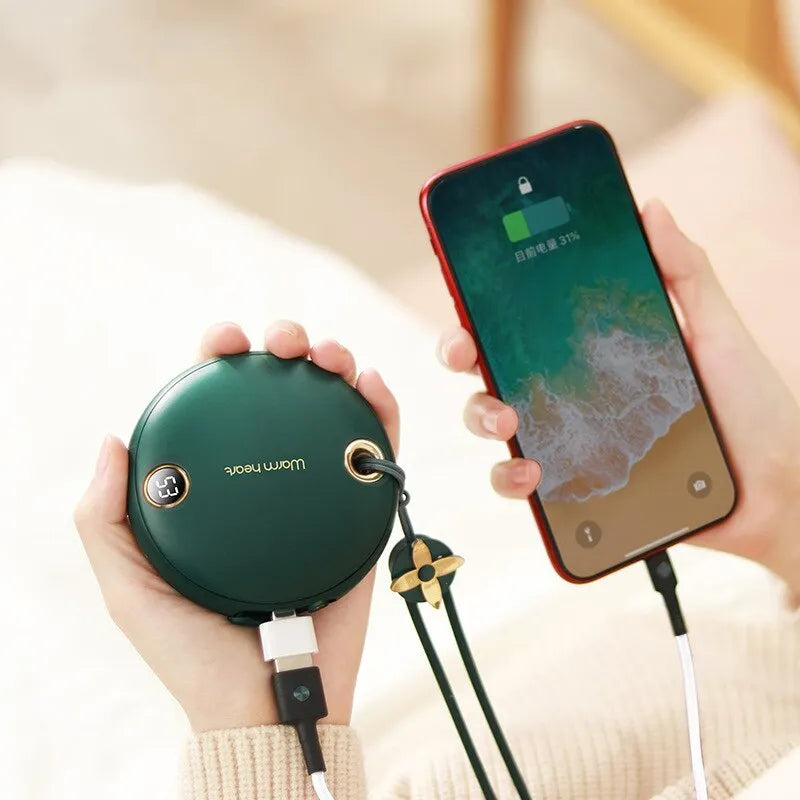 Green hand warmer power bank with digital display showing charge level, next to a charging cable.