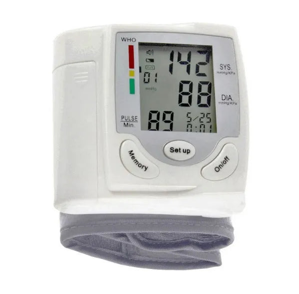 Grey portable wrist blood pressure monitor with digital display on a wrist.
