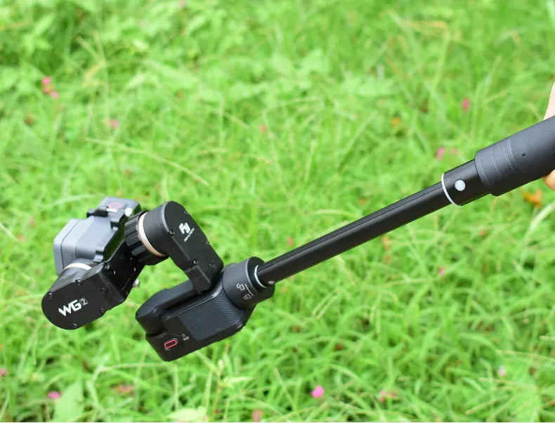 Black retractable aluminium selfie stick with Bluetooth remote, extended with a phone in the holder.