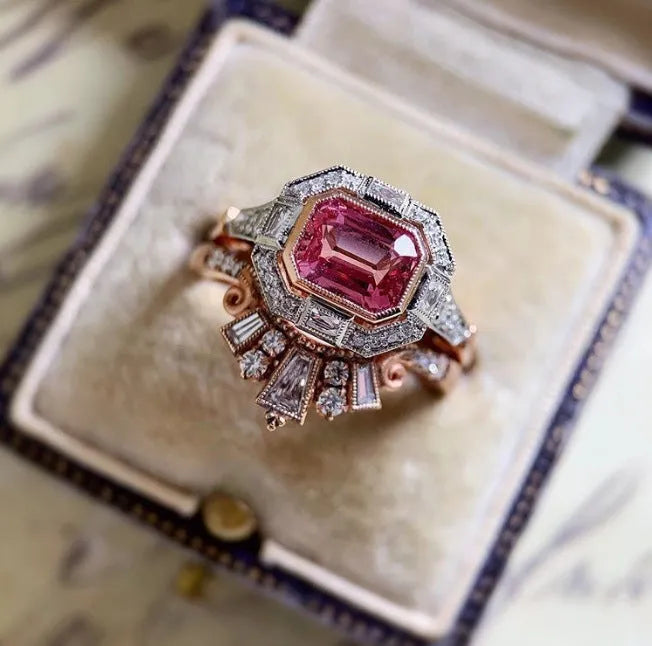 Retro style rose gold women's ring with a geometric shape and central ruby stone.