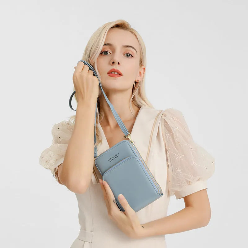 Green crossbody bag with tri-fold pockets and zipper closure on white background
