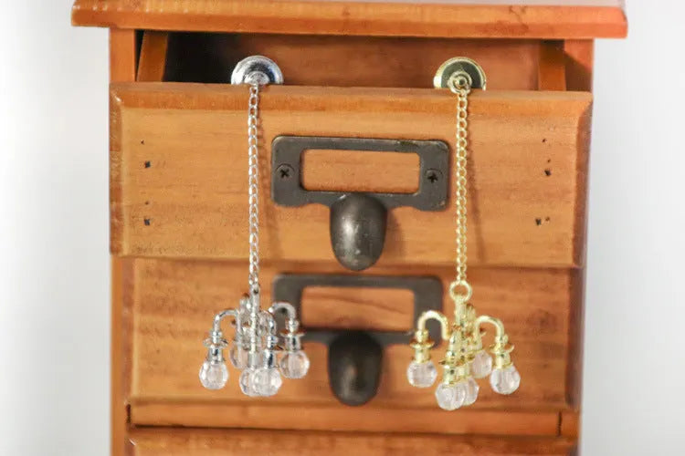 A small gold or silver metal photo prop decoration measuring 5 by 2 centimetres.