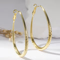 Gold glossy egg-shaped spring fastener earrings made from hypoallergenic copper, unisex geometric design