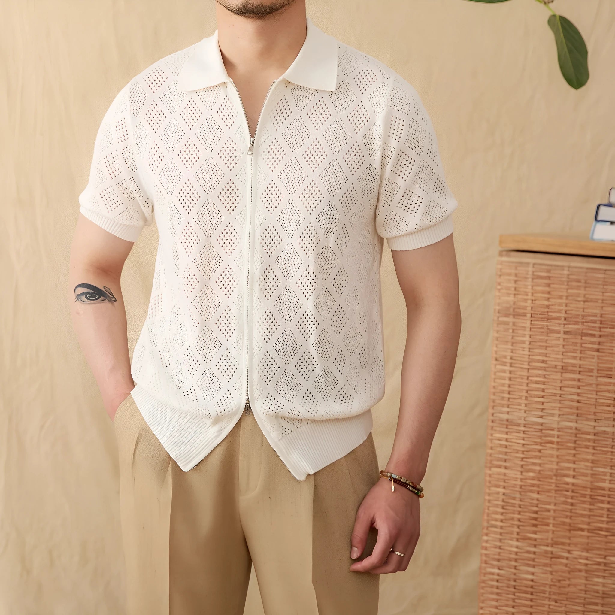 Man wearing a light brown, short sleeve cotton cardigan with a front zipper and lapel collar.