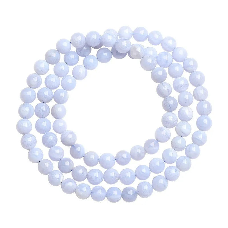 Blue agate bead bracelet with striped patterns and a Ruyi charm on a white background.