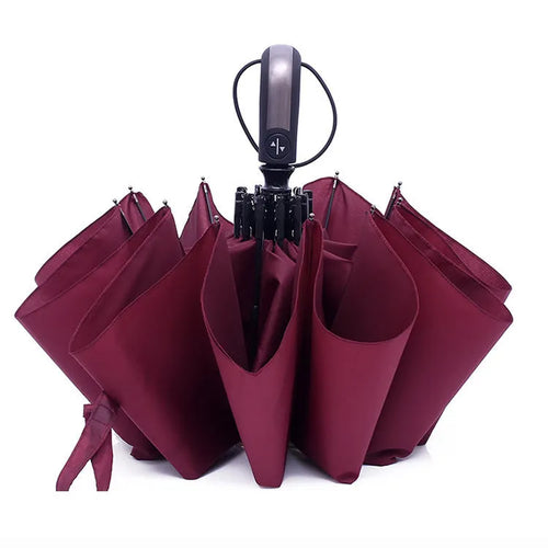 Automatic triple-folding business umbrella with a large black canopy, showing the rubber handle and steel ribs.