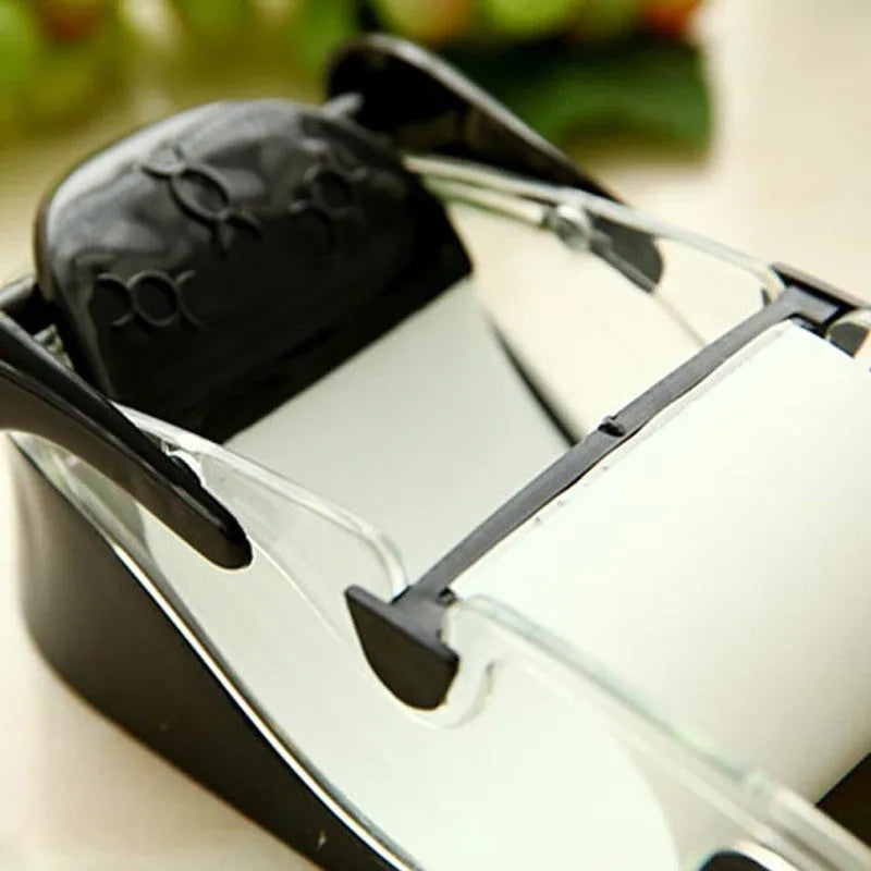 Black DIY plastic kitchen roll sushi machine on a flat surface with lever and roller band visible