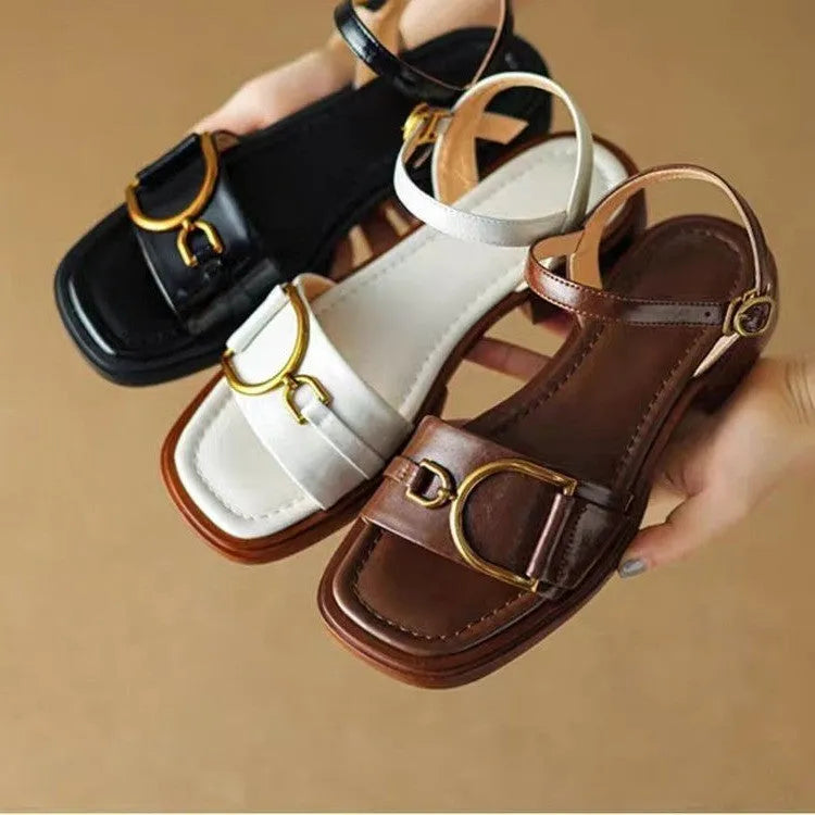 Women's black leather sandals with a thick rubber sole and buckle fastening.