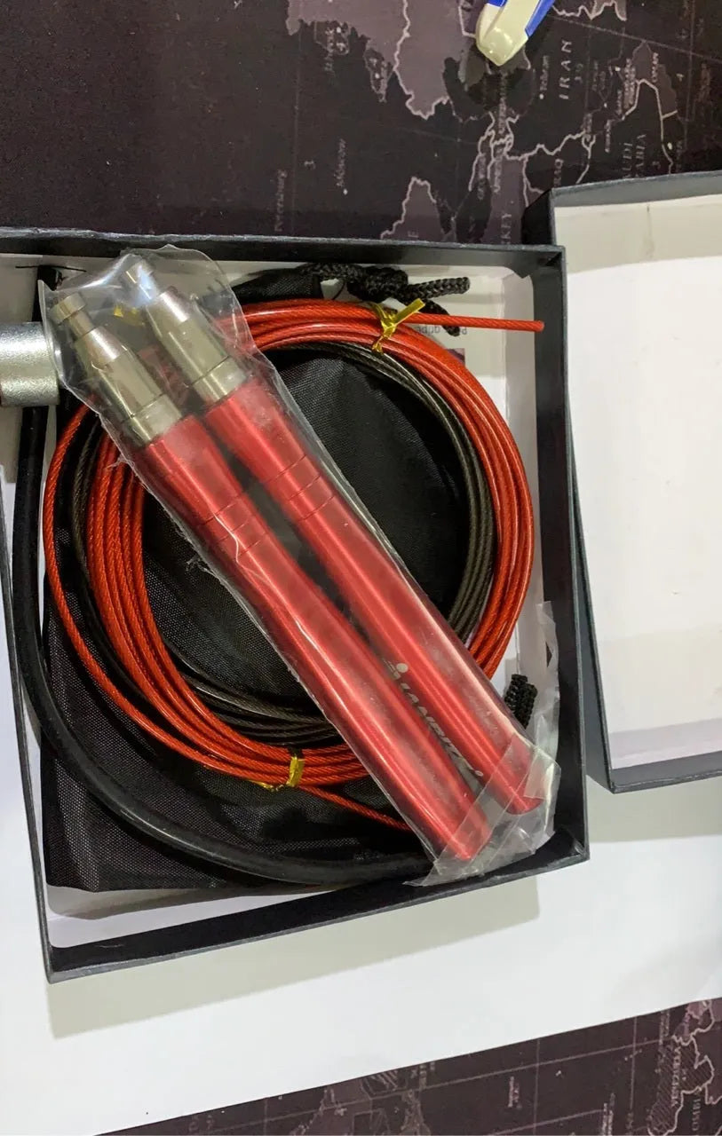 Sports skipping rope with aluminium alloy handles and black wire PVC rope on a smooth floor