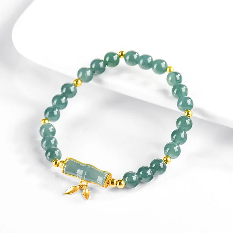Simple sterling silver bracelet with a raised setting holding a natural blue jade round bead.