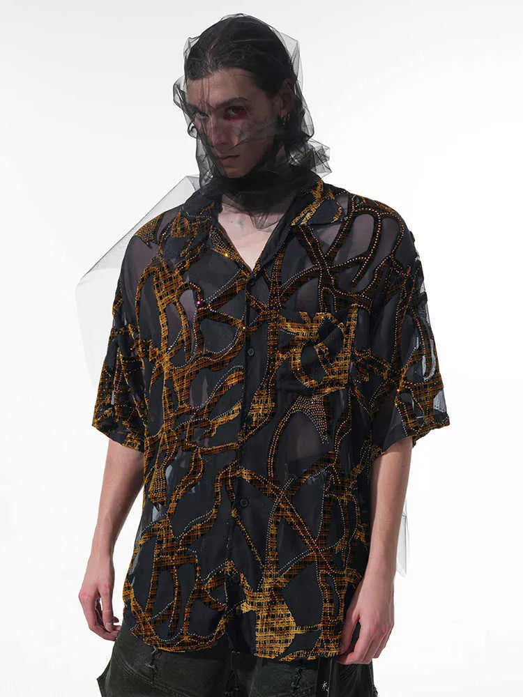 Man wearing a loose-fit black short-sleeved shirt with a translucent snake pattern print and lapel collar.