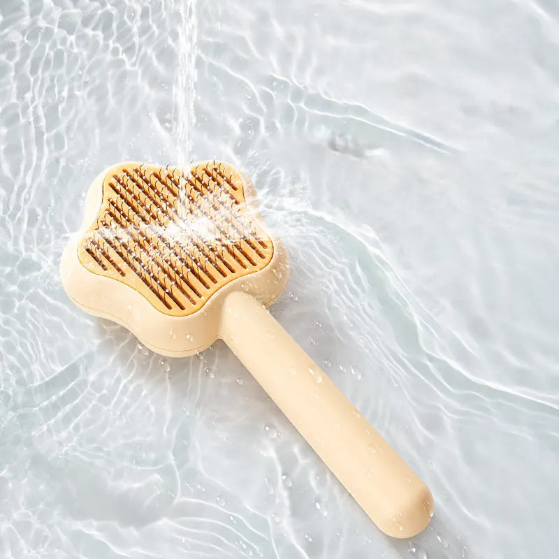 Green self-cleaning stainless steel magic wand cat comb on a white background.