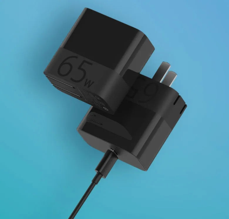 Black ZMI USB-C 65W notebook power adapter showing compact size next to a USB-C cable.