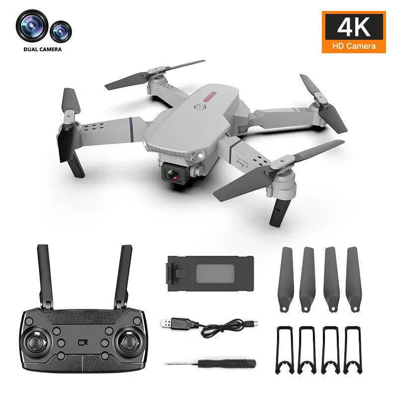 Grey foldable 4K dual camera drone with remote control, spare blades, and charging cable on a neutral background.