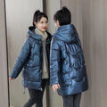 Women's green ultra-thin hooded winter jacket with long sleeves on a hanger.
