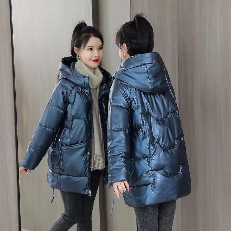 Women's green ultra-thin hooded winter jacket with long sleeves on a hanger.