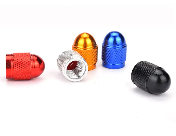 Aluminium alloy mountain bike tyre valve cap in assorted colours on a bicycle wheel.