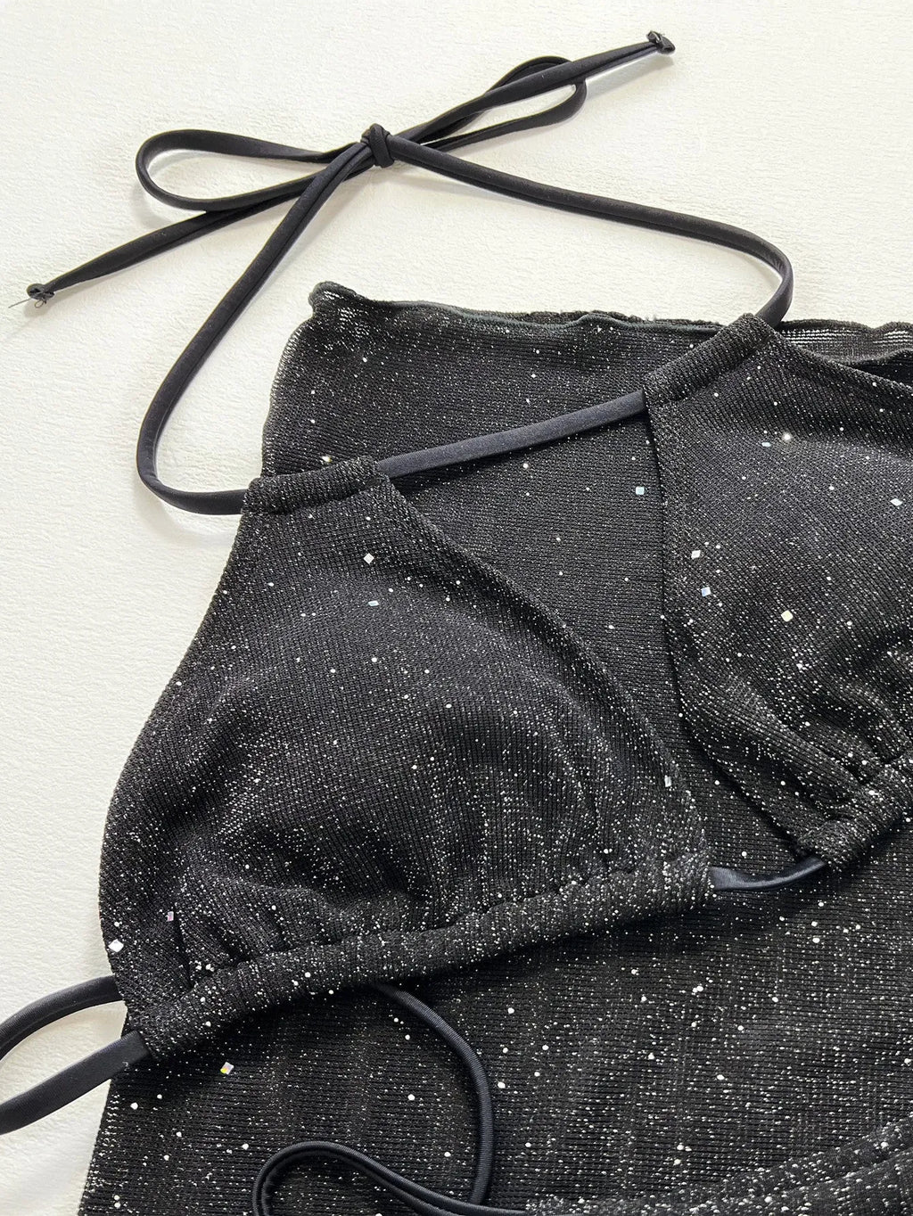 Black three-piece bikini swimsuit set with top and shorts on mannequin
