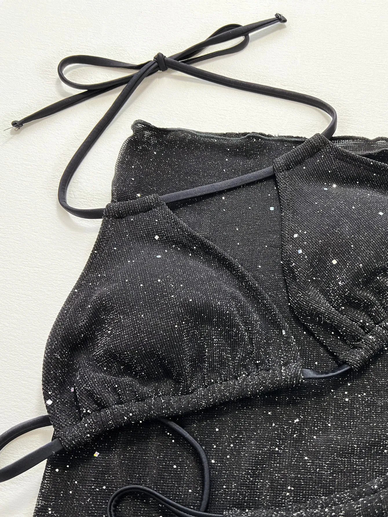 Black three-piece bikini swimsuit set with top and shorts on mannequin