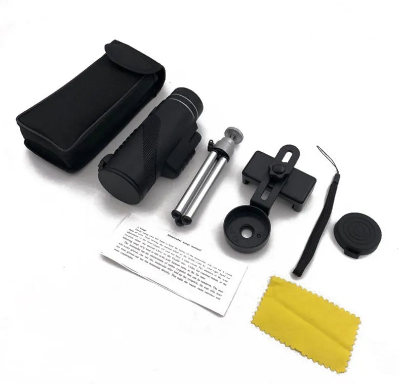 Black 40x60 monocular telescope with mobile phone attachment for photography on a table.