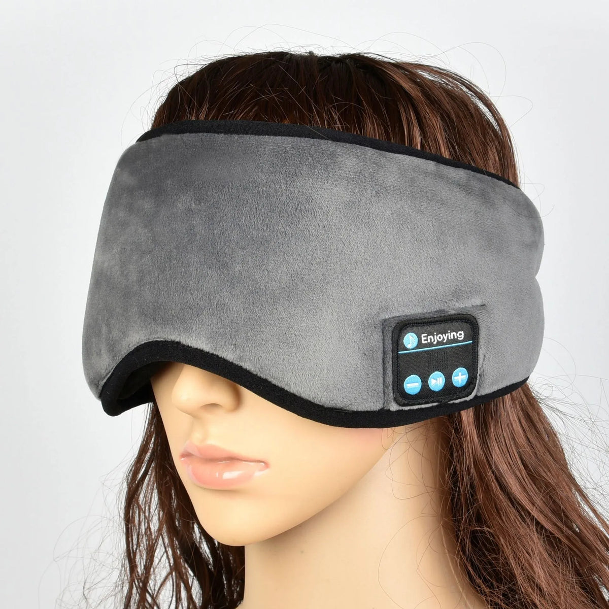 Black sleep eye mask with soft silk fabric, adjustable strap, and carry case on a light background