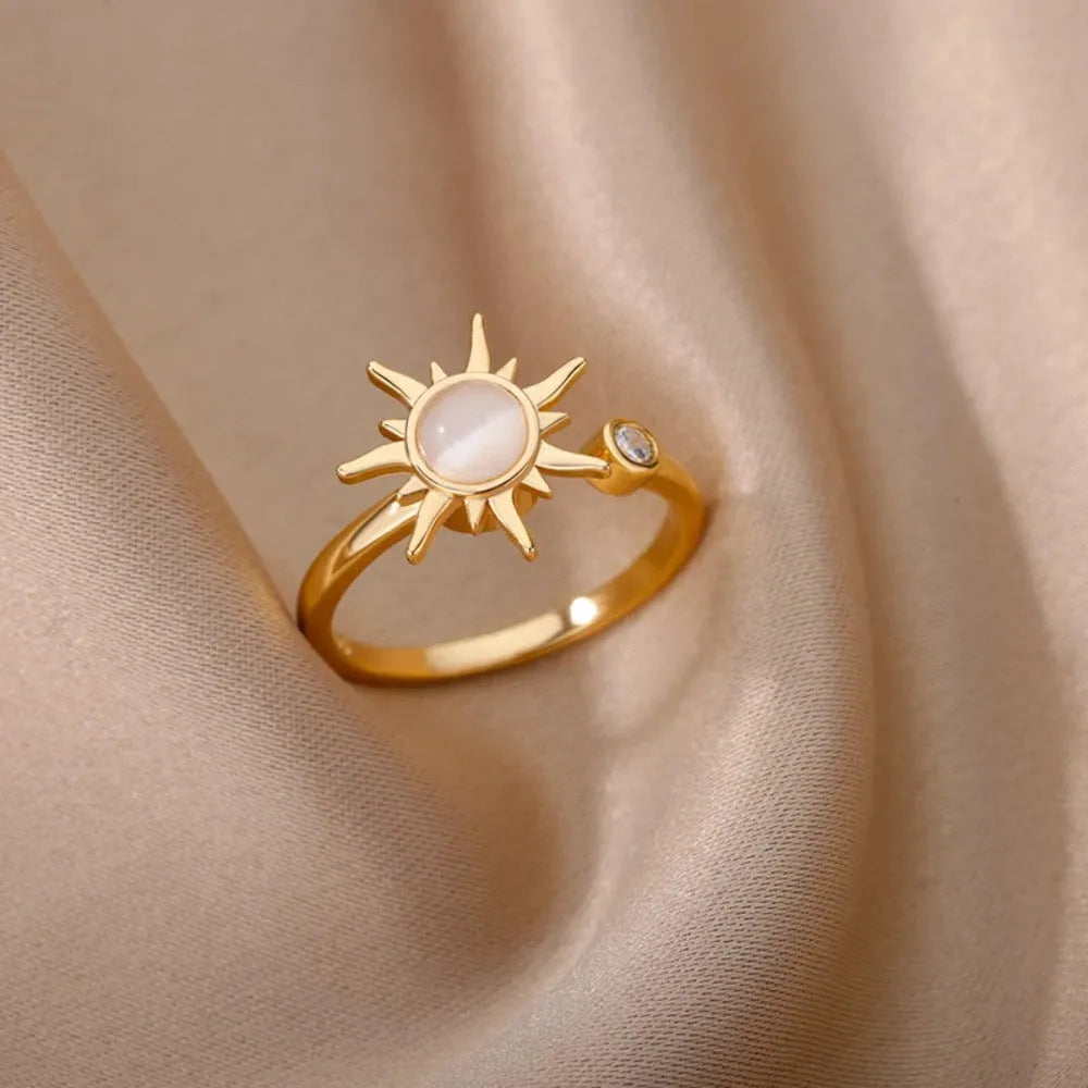 A geometric gold-coloured ring with an adjustable opening, shown rotating on a finger.
