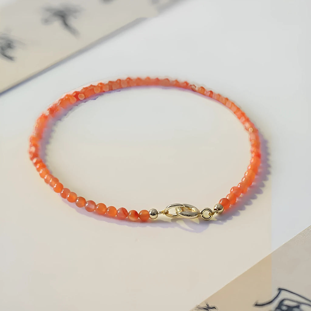 Women's retro-style bracelet with natural southern red agate stones in red colours on a white background.