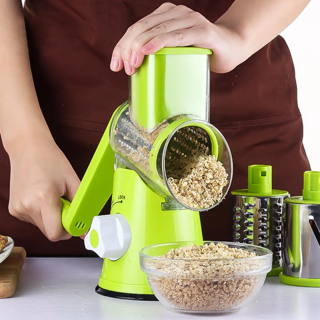 Blue green mandoline vegetable slicer with three stainless steel blades and a white suction cup base on a kitchen counter.