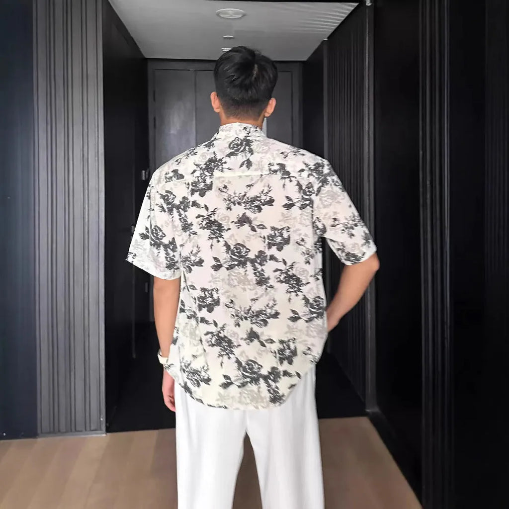 A loose-fitting, short sleeve casual shirt with a floral print, shown in a cardigan style.