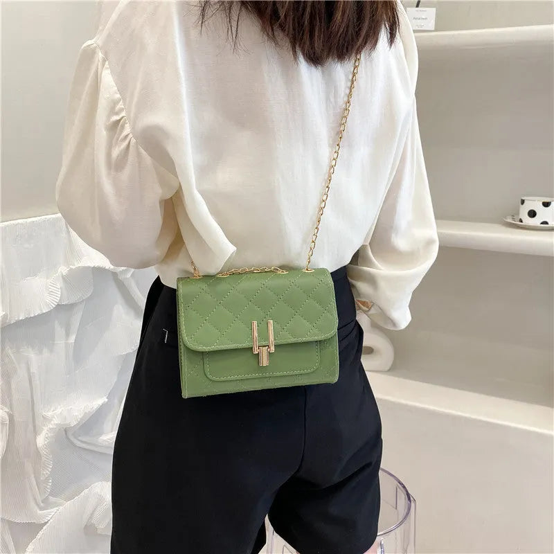 Women's minimalist crossbody bag with diamond lattice chain strap in black, green, or white.
