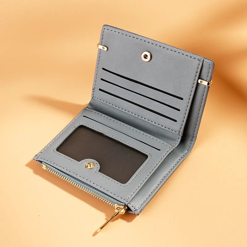 Compact black PU leather ladies wallet open to show card slots, bill compartment, change slot, and zippered section.