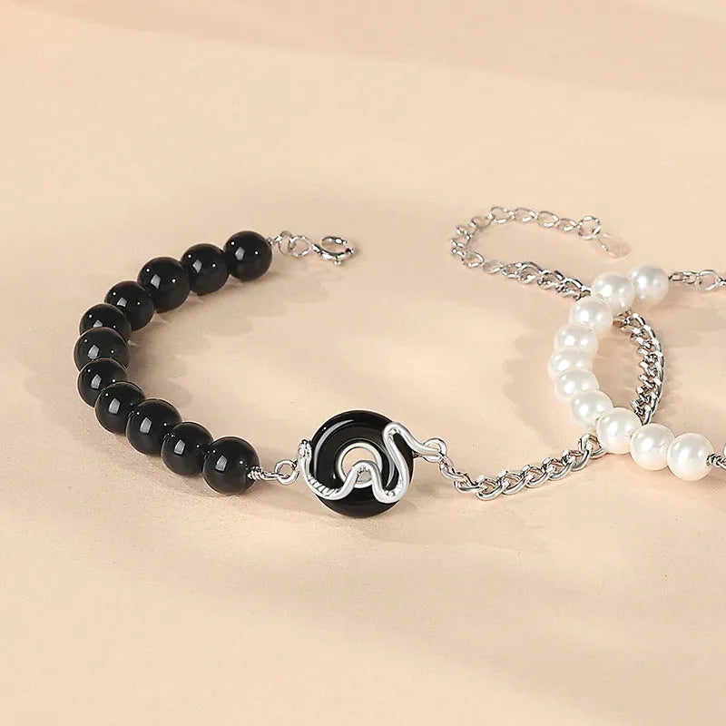 Close-up of a 925 sterling silver bracelet with a snake design, obsidian pearl, and a safe buckle clasp.