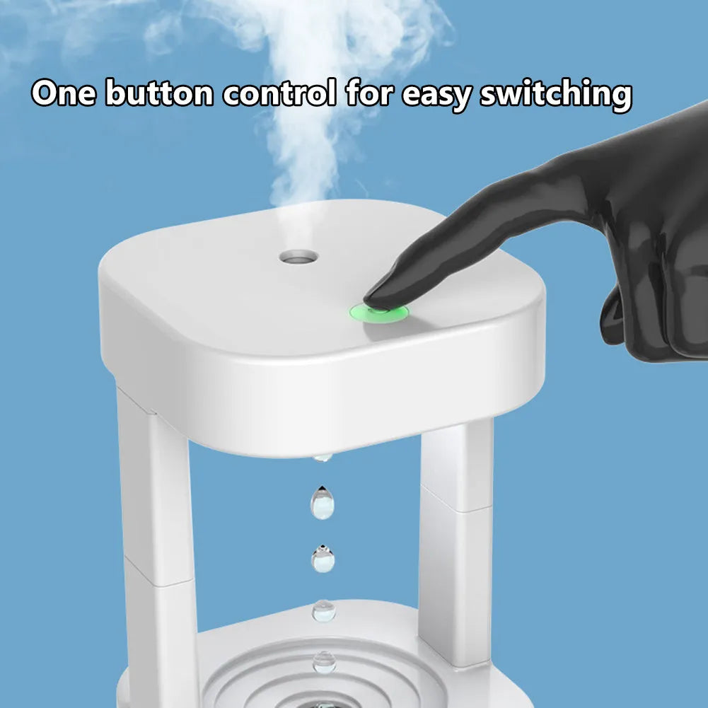 White anti-gravity water drop humidifier with coloured light on a desk next to USB cable